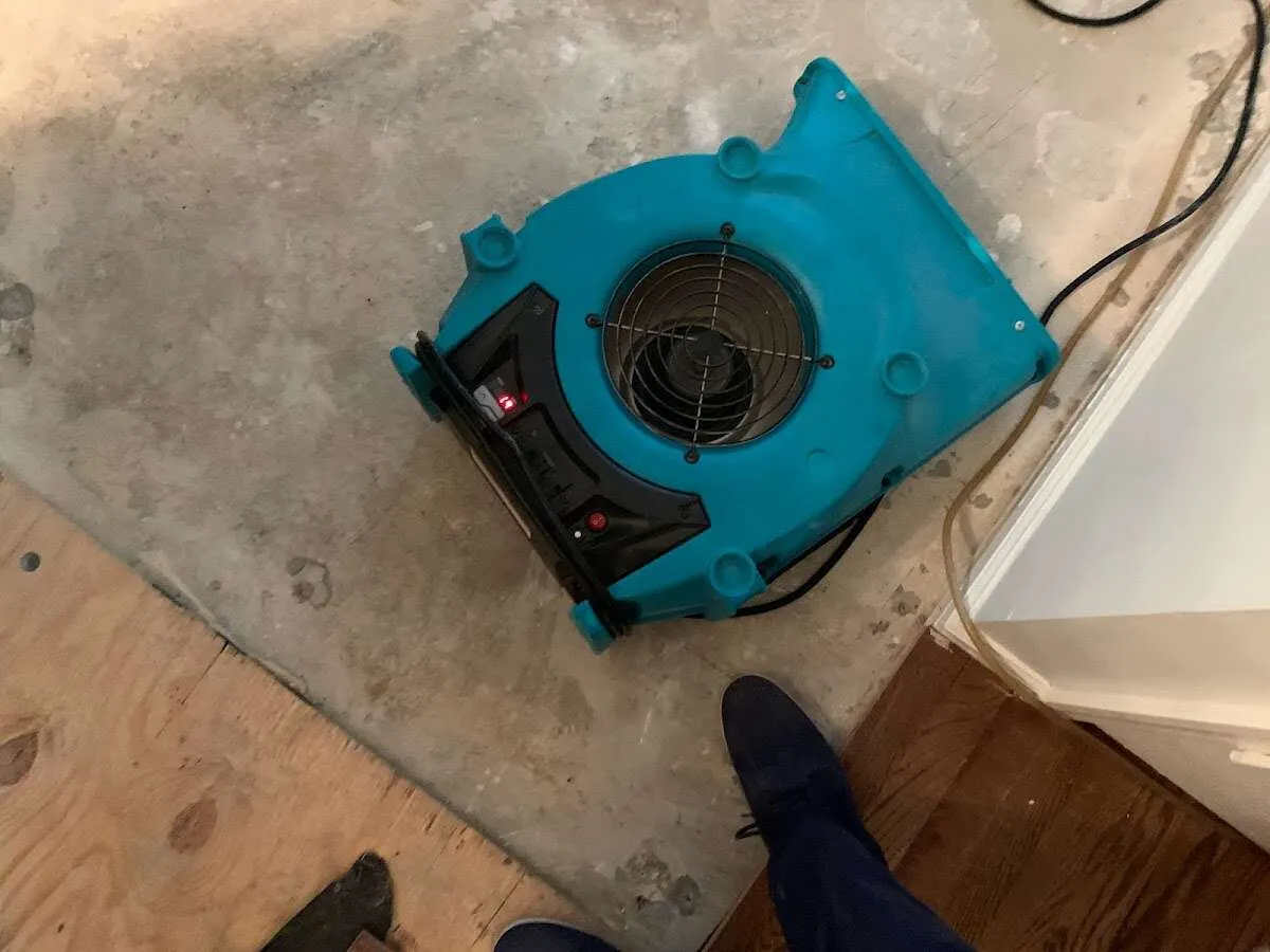 Air mover drying subfloor during Commercial Water Damage Restoration in Tucker